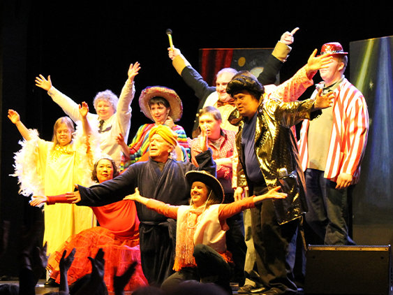 Creative partners theatre group on stage raising hands